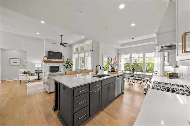 11573 S Mize Rd, Olathe, KS 66061 - kitchen featuring a sink, a ceiling fan, light countertops, a fireplace, and stainless steel appliances