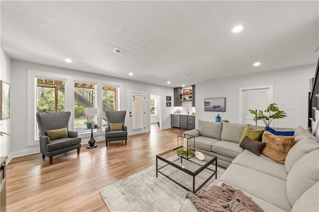 11573 S Mize Rd, Olathe, KS 66061 - living area with light wood-type flooring, recessed lighting, a textured ceiling, and baseboards
