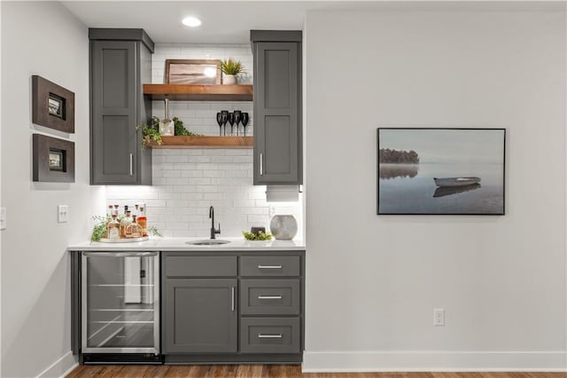 11573 S Mize Rd, Olathe, KS 66061 - indoor wet bar featuring wine cooler, decorative backsplash, baseboards, wood finished floors, and recessed lighting