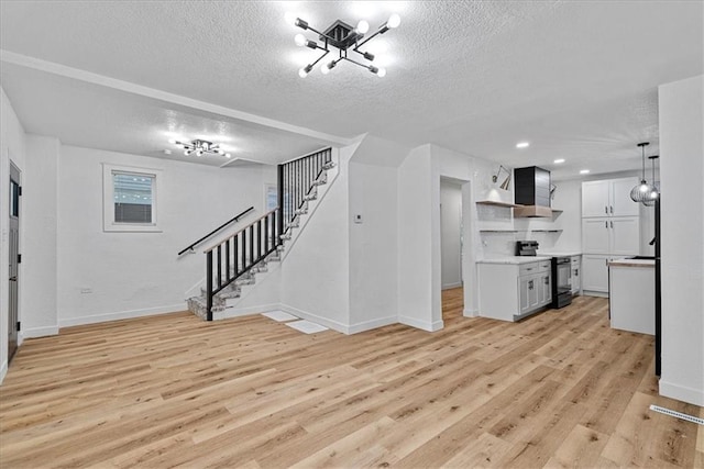 527 Cypress Ave, Kansas City, MO 64124 - unfurnished living room featuring a textured ceiling, stairway, light wood-style flooring, baseboards, and recessed lighting