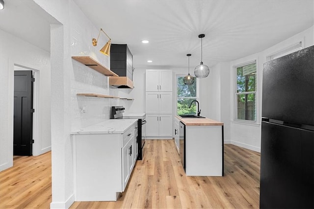527 Cypress Ave, Kansas City, MO 64124 - kitchen with black appliances, open shelves, butcher block countertops, a sink, and light wood-style flooring