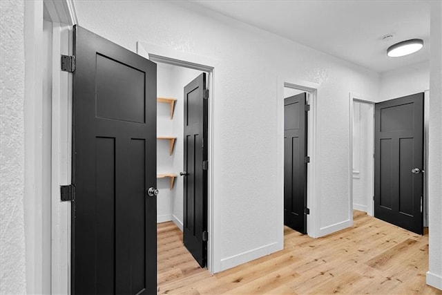 527 Cypress Ave, Kansas City, MO 64124 - corridor featuring light wood finished floors, a textured wall, and baseboards