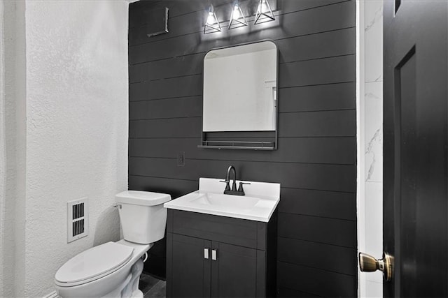527 Cypress Ave, Kansas City, MO 64124 - bathroom with vanity, toilet, and a textured wall