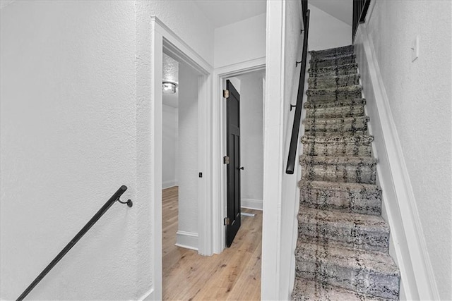 527 Cypress Ave, Kansas City, MO 64124 - stairway with wood finished floors, a textured wall, and baseboards