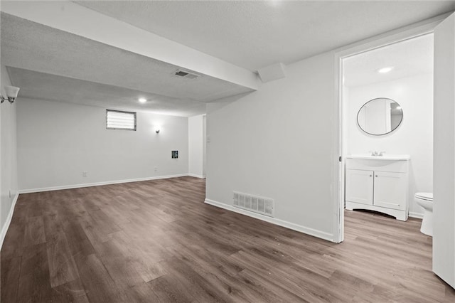 8003 E 118th Ter, Kansas City, MO 64134 - finished basement with wood finished floors, baseboards, and a sink