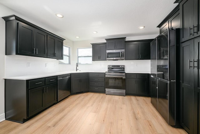 1012 2nd St, Perry, KS 66073 - kitchen featuring stainless steel appliances, light wood finished floors, decorative backsplash, recessed lighting, and light countertops