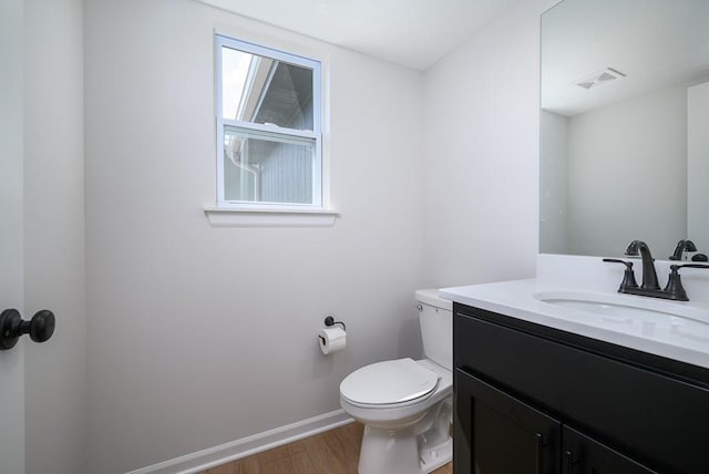 1012 2nd St, Perry, KS 66073 - half bath featuring wood finished floors, toilet, baseboards, and vanity