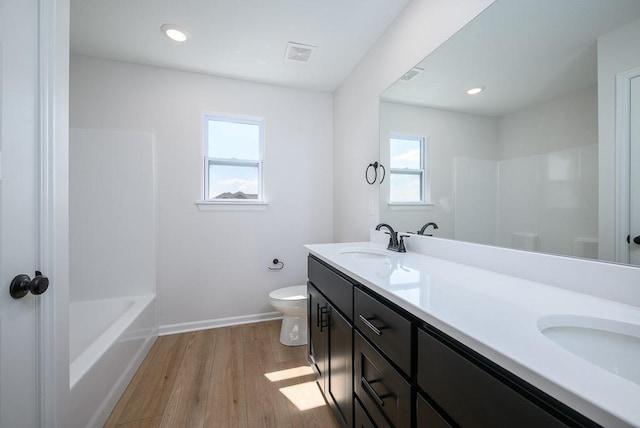 1012 2nd St, Perry, KS 66073 - full bath with toilet, wood finished floors, double vanity, baseboards, and recessed lighting