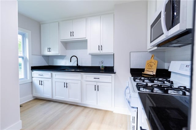 3312 Delavan Ave, Kansas City, KS 66104 - kitchen featuring white appliances, a sink, white cabinetry, light wood-style flooring, and backsplash