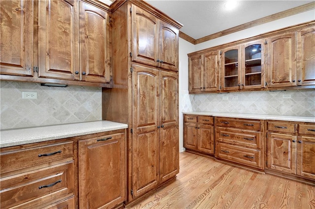 4641 SW Soldier Dr, Lees Summit, MO 64082 - kitchen featuring brown cabinetry, crown molding, light countertops, and backsplash