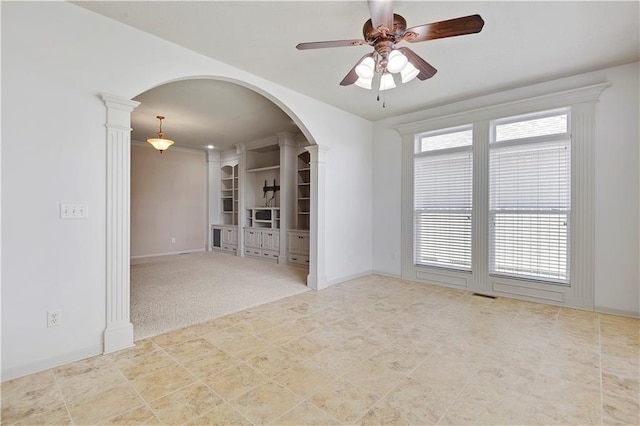 4641 SW Soldier Dr, Lees Summit, MO 64082 - unfurnished living room with arched walkways, ceiling fan, baseboards, and ornate columns
