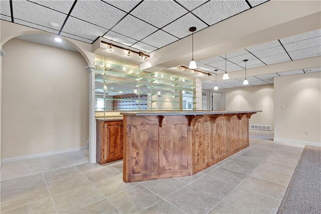 4641 SW Soldier Dr, Lees Summit, MO 64082 - indoor wet bar with baseboards, a paneled ceiling, arched walkways, and light tile patterned floors