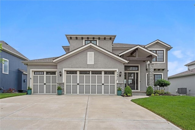 24957 W 98th St, Lenexa, KS 66227 - view of front of property featuring stucco siding, an attached garage, stone siding, a front lawn, and driveway