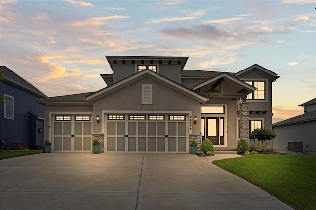 24957 W 98th St, Lenexa, KS 66227 - view of front of home with stone siding, an attached garage, stucco siding, and driveway