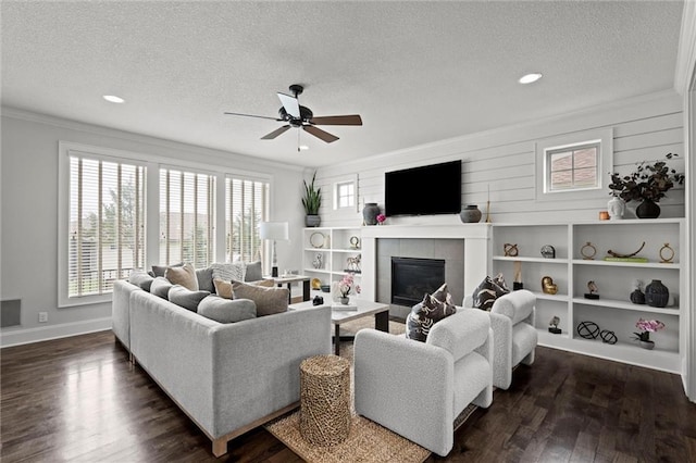 24957 W 98th St, Lenexa, KS 66227 - living room with a textured ceiling, crown molding, ceiling fan, a tile fireplace, and dark wood finished floors