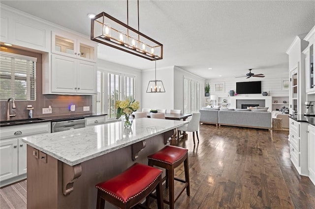 24957 W 98th St, Lenexa, KS 66227 - kitchen featuring a sink, ceiling fan, dishwasher, tasteful backsplash, and a fireplace