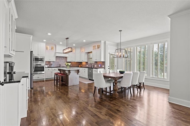 24957 W 98th St, Lenexa, KS 66227 - dining room featuring dark wood-style flooring, a textured ceiling, a chandelier, ornamental molding, and recessed lighting
