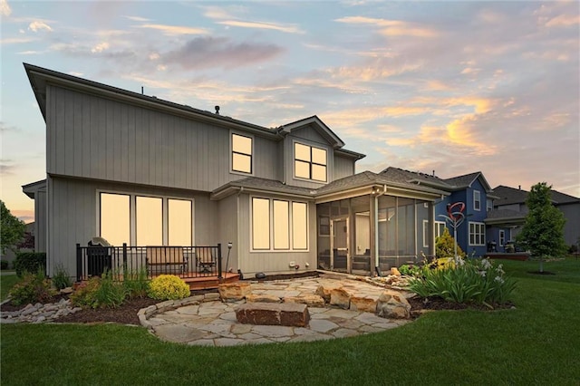 24957 W 98th St, Lenexa, KS 66227 - back of house featuring a sunroom, a yard, a deck, and a fire pit