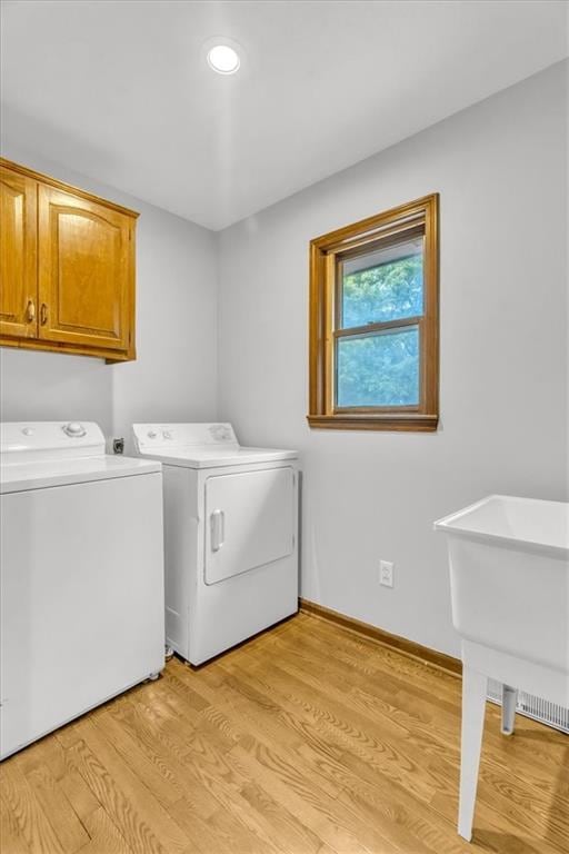 1600 NE 97th St, Kansas City, MO 64155 - laundry area featuring washer and clothes dryer, cabinet space, light wood-style floors, baseboards, and recessed lighting