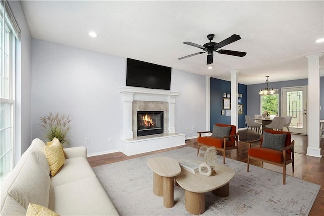 417 N Locust St, Gardner, KS 66030 - living area with dark wood finished floors, recessed lighting, a glass covered fireplace, ceiling fan, and decorative columns