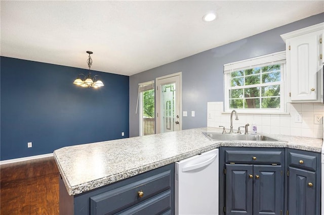 417 N Locust St, Gardner, KS 66030 - kitchen featuring white dishwasher, a peninsula, dark wood-style flooring, white cabinets, and a chandelier