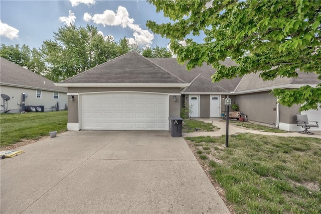 ranch-style house with a garage, a front yard, stucco siding, and concrete driveway
