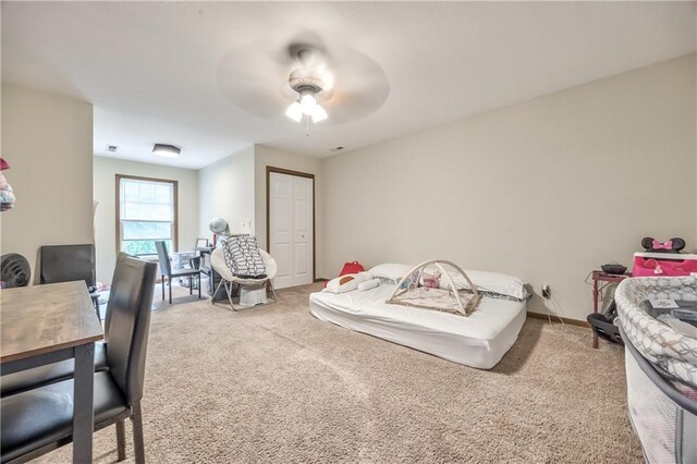 carpeted bedroom featuring ceiling fan, a closet, and baseboards