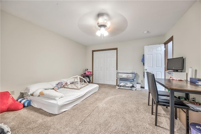 bedroom featuring carpet flooring, a closet, a desk, and a ceiling fan