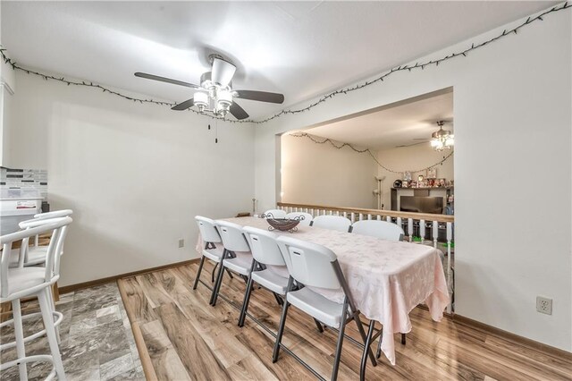 dining space featuring a ceiling fan, light wood-style floors, and baseboards