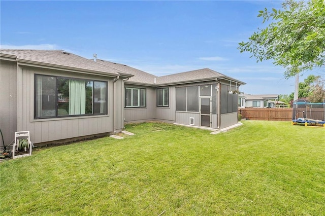 301 Sunrise Dr, Louisburg, KS 66053 - rear view of house with a trampoline, a sunroom, and a shingled roof