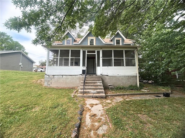 view of front facade with a sunroom and a front lawn