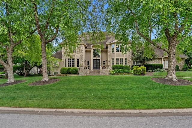 12613 Sherwood St, Leawood, KS 66209 - tudor home with stone siding, a front lawn, french doors, and stucco siding