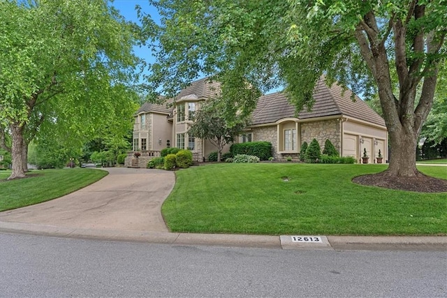 12613 Sherwood St, Leawood, KS 66209 - view of front of property featuring stone siding, a front lawn, and a garage