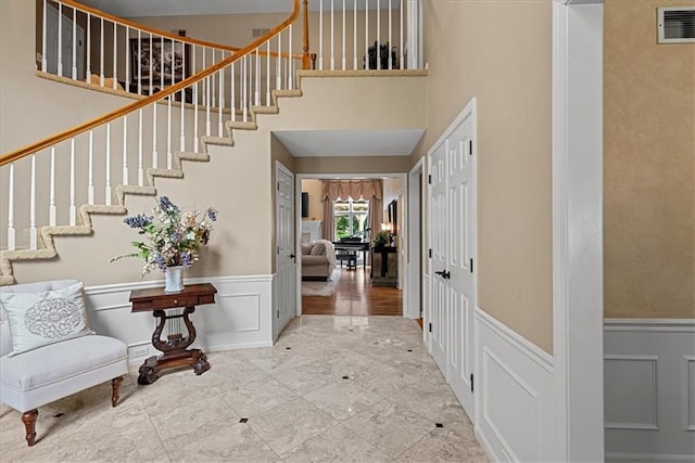 12613 Sherwood St, Leawood, KS 66209 - foyer with stairs, a wainscoted wall, a decorative wall, and a high ceiling
