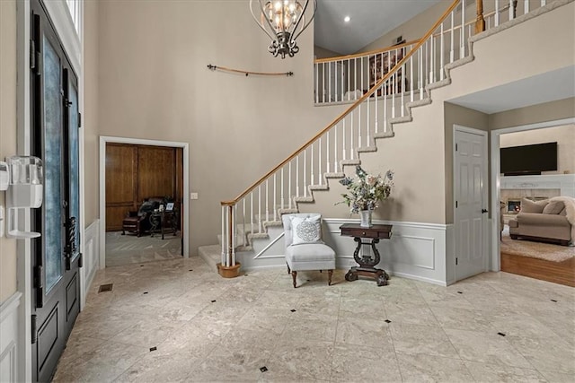 12613 Sherwood St, Leawood, KS 66209 - entryway with a towering ceiling, stairs, wainscoting, a chandelier, and a decorative wall