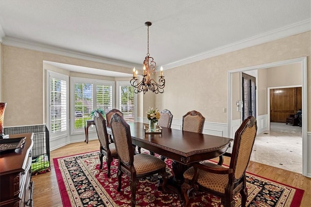 12613 Sherwood St, Leawood, KS 66209 - dining area featuring a chandelier, ornamental molding, light wood-type flooring, and wainscoting