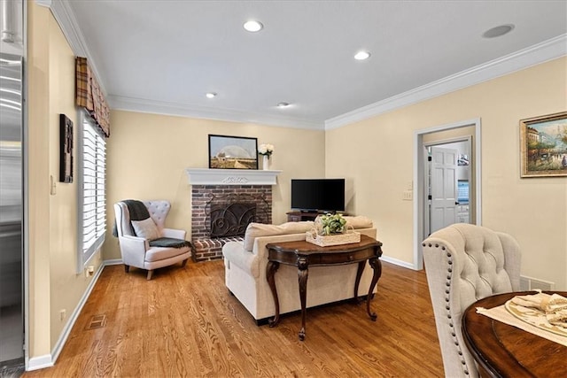 12613 Sherwood St, Leawood, KS 66209 - living area featuring light wood finished floors, ornamental molding, baseboards, a brick fireplace, and recessed lighting