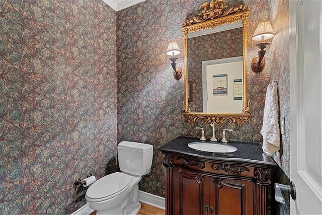 12613 Sherwood St, Leawood, KS 66209 - bathroom with vanity, wallpapered walls, toilet, crown molding, and baseboards