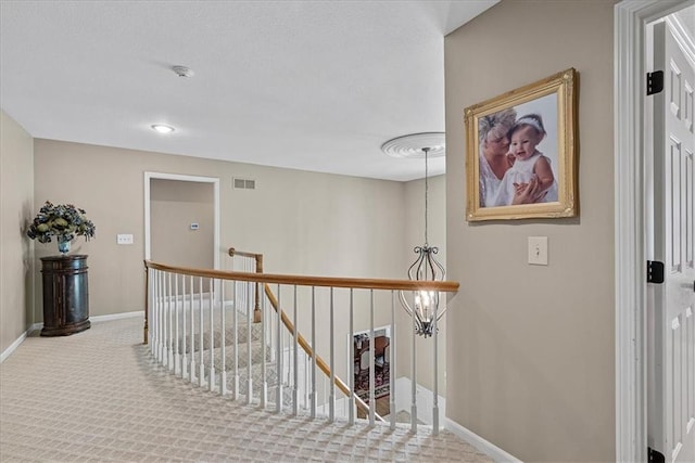 12613 Sherwood St, Leawood, KS 66209 - hall featuring baseboards, an upstairs landing, carpet floors, and a chandelier