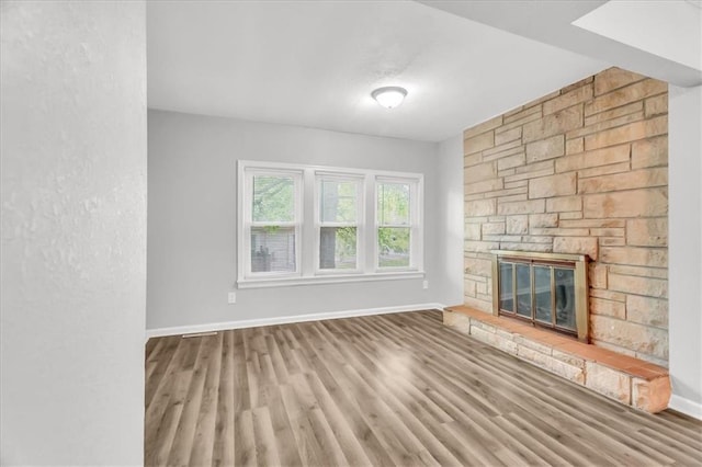 315 S Crane St S, Independence, MO 64050 - unfurnished living room featuring a fireplace, baseboards, and wood finished floors