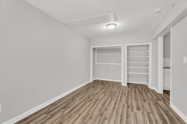 315 S Crane St S, Independence, MO 64050 - unfurnished bedroom with wood finished floors, multiple closets, and baseboards