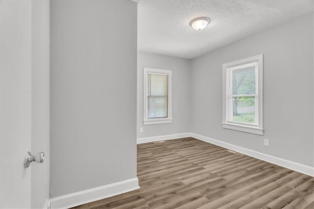 315 S Crane St S, Independence, MO 64050 - spare room featuring baseboards, a textured ceiling, and wood finished floors
