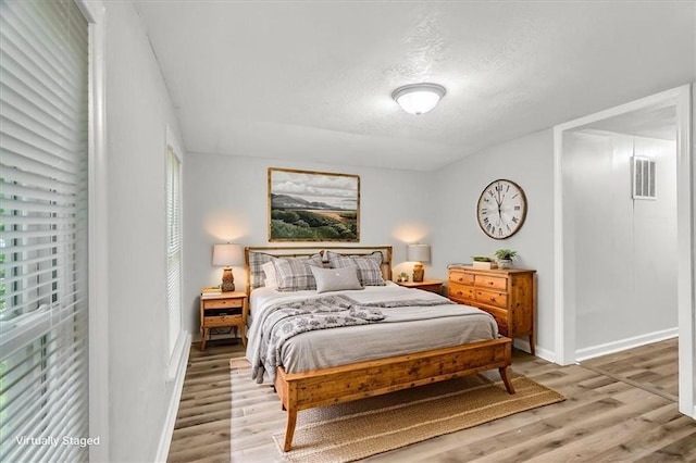 315 S Crane St S, Independence, MO 64050 - bedroom featuring light wood finished floors, a textured ceiling, and baseboards