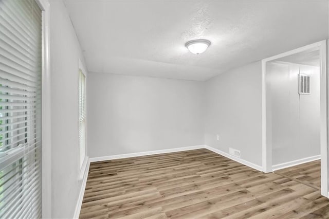 315 S Crane St S, Independence, MO 64050 - spare room with wood finished floors, a textured ceiling, and baseboards