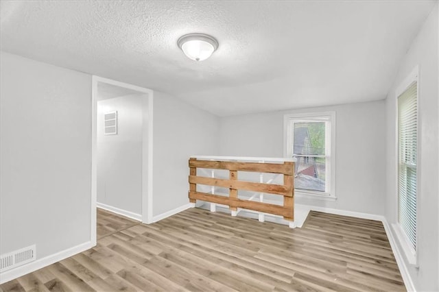 315 S Crane St S, Independence, MO 64050 - empty room featuring wood finished floors, a textured ceiling, and baseboards