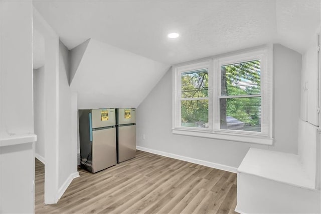 315 S Crane St S, Independence, MO 64050 - bonus room with baseboards, lofted ceiling, light wood-style floors, and a textured ceiling