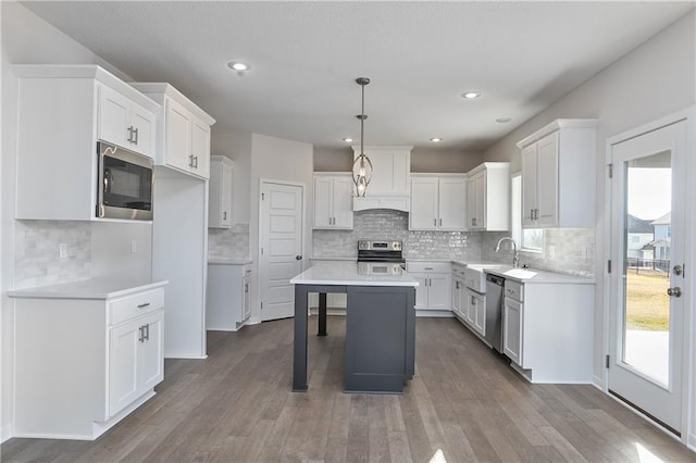kitchen with stainless steel appliances, a sink, tasteful backsplash, wood-type flooring, and recessed lighting