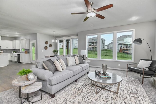 living area featuring ceiling fan and dark wood-type flooring
