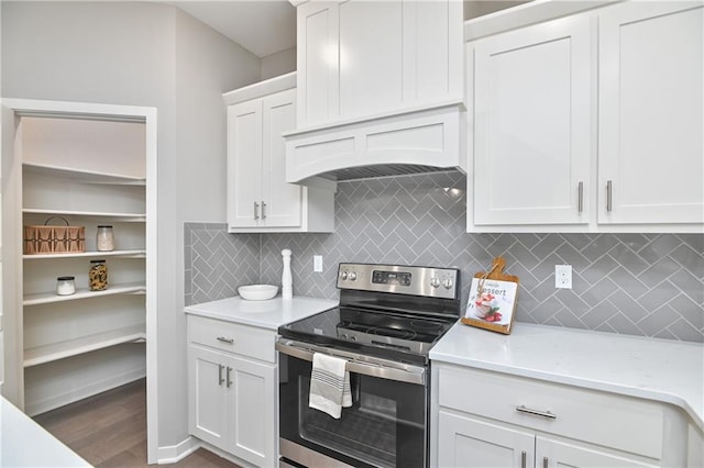 kitchen featuring stainless steel electric stove, white cabinets, decorative backsplash, and dark wood-style flooring