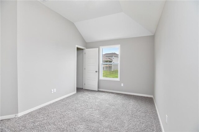 unfurnished bedroom with carpet, vaulted ceiling, and baseboards